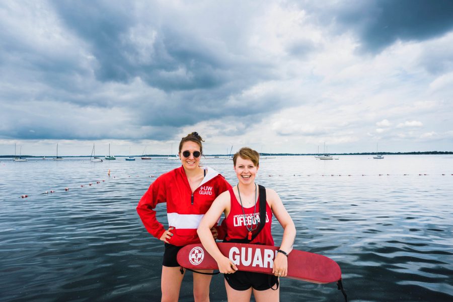 lifeguards smiling in their lifeguard suits, cloudy day on lake mendota