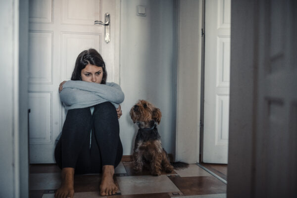 woman sitting exhausted on the floor with her dog