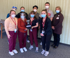 Medical staff members are pictured standing in the clinic space with the tropy