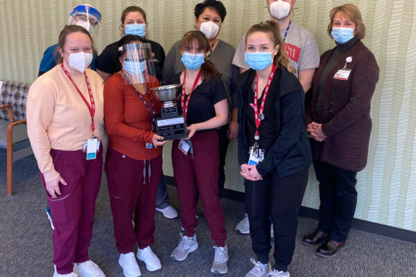 Medical staff members are pictured standing in the clinic space with the tropy