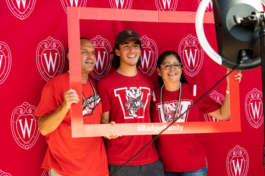 A student and their parents show school spirit as they pose for a photo.