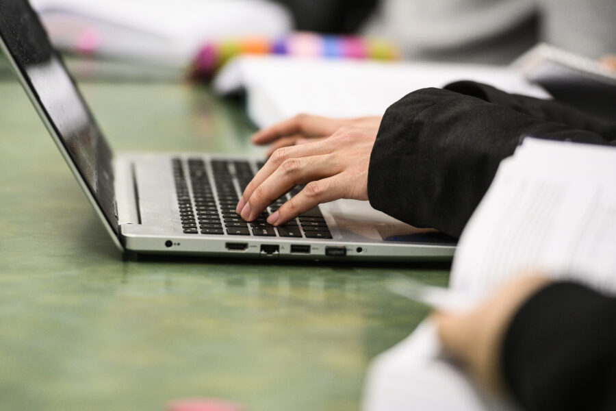 Hands on a laptop keyboard.