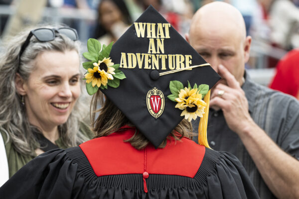 Black graduation cap that reads "What an adventure"
