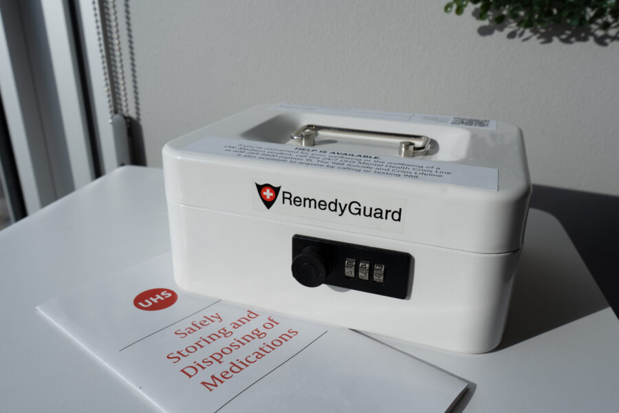 White medication lockbox with brochure on safely disposing of and storing medications