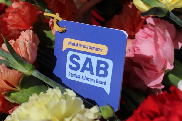 Tag that says "Mental Health Services SAB" with flowers in the background.