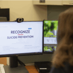 A person with long brown hair looks at a computer screen displaying the Recognize, Respond, Refer online suicide prevention training