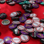 Badger Recovery pins arranged on a red tablecloth