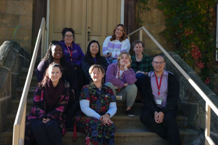 Photo of the Survivor Services professional team sitting on stairs