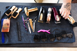 hair clippers, scissors, and brushes on a towel