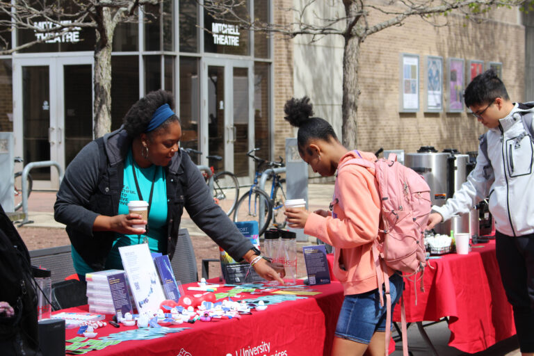 UHS provider speaks with student at tabling event during Sexual Assault Awareness Month