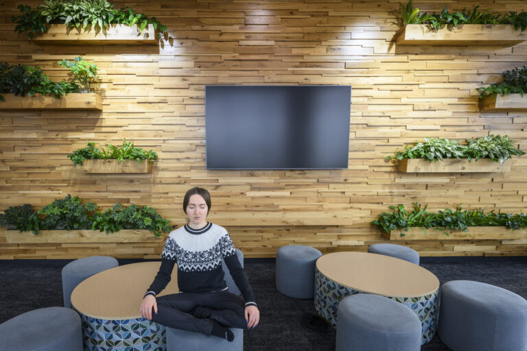 person practicing meditation and mindfulness seated criss cross on a stool