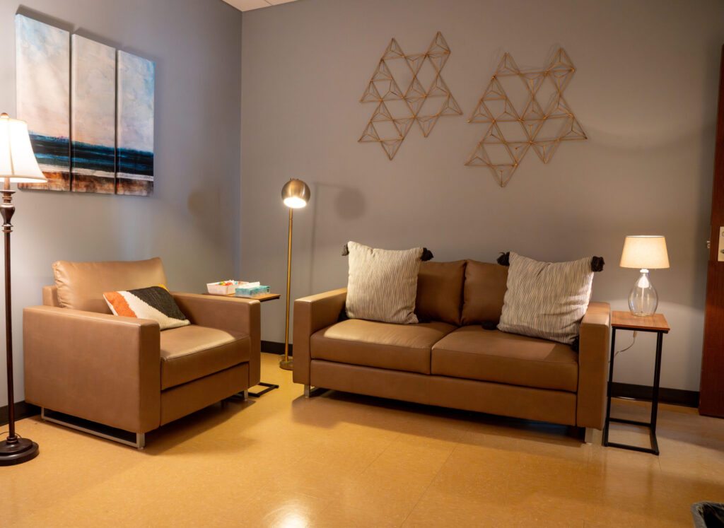 Sexual Assault Forensic Exam room in the Survivor Services suite. Two couches are pictured with art and lamps.
