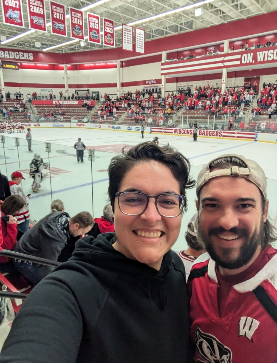 Mariessa Robles smiling with friednat UW Women's Hockey game.