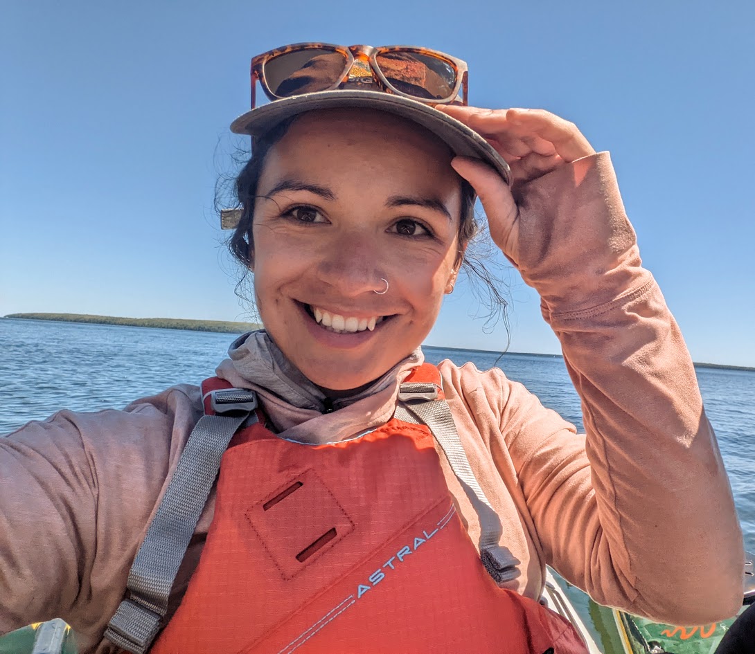 Rhiannon Kunesh smiling on a kayak on the water.