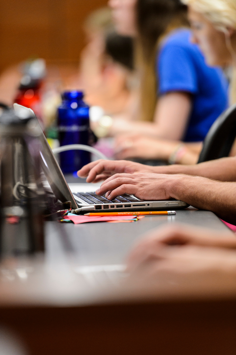 A person types on a laptop