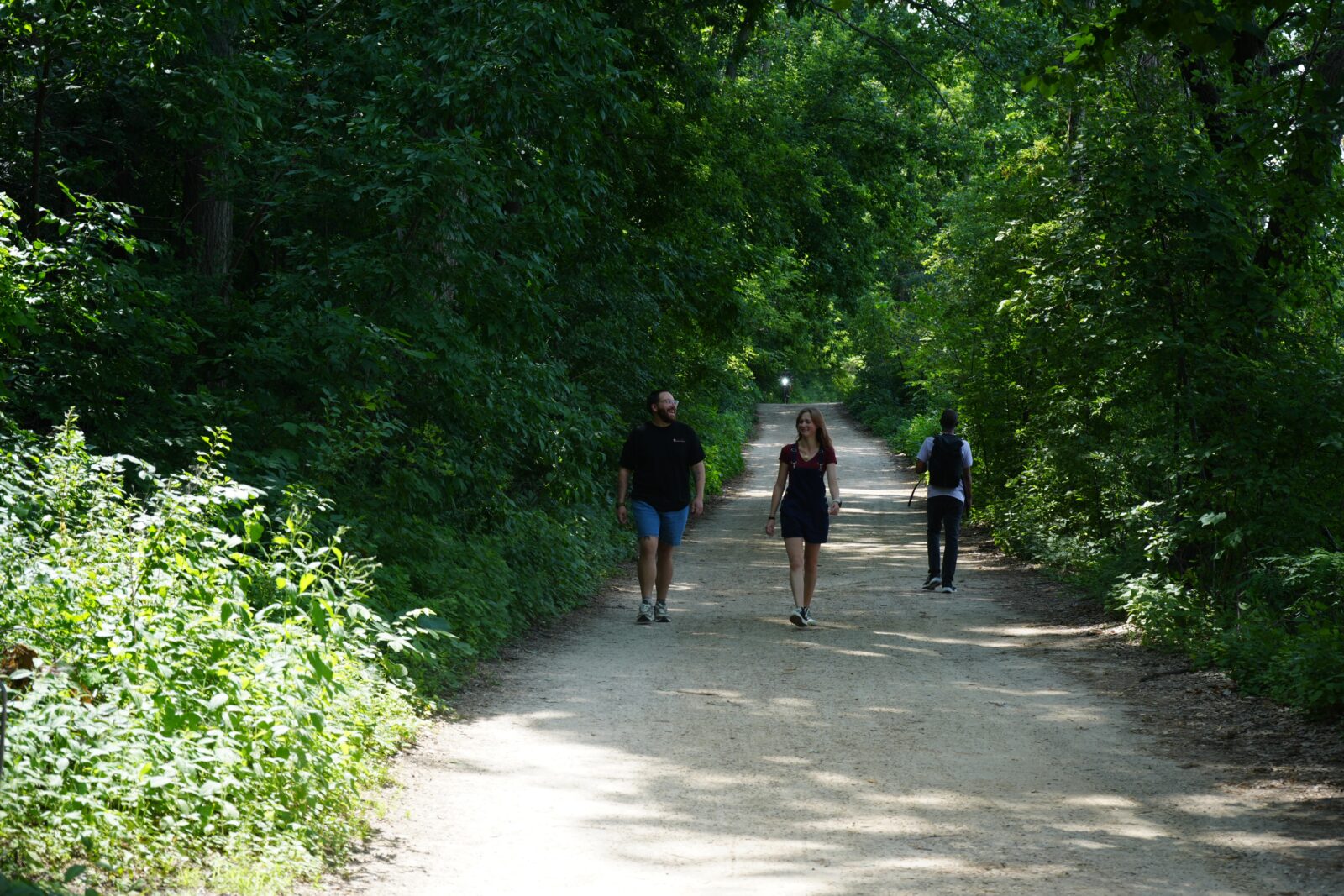Mental Health Provider Charles Woods walks along a path with a student.