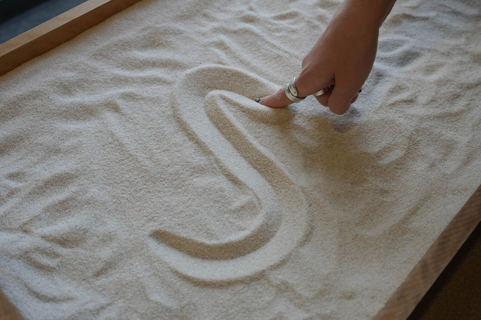 Finger drawing in the sand.