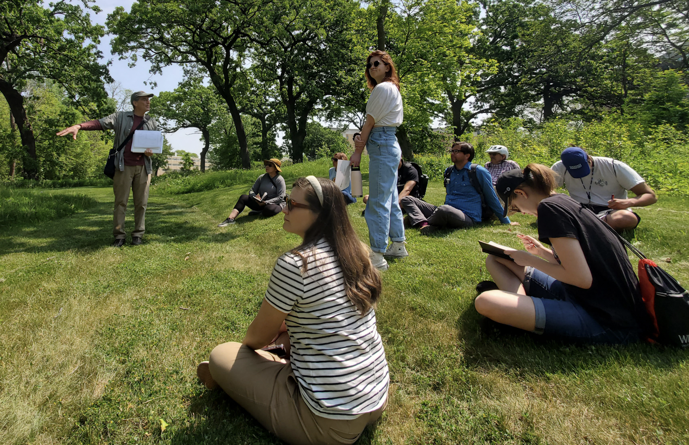 Group of people seated as they listen to their tour guide on the First Nations Cultural Landscape Tour