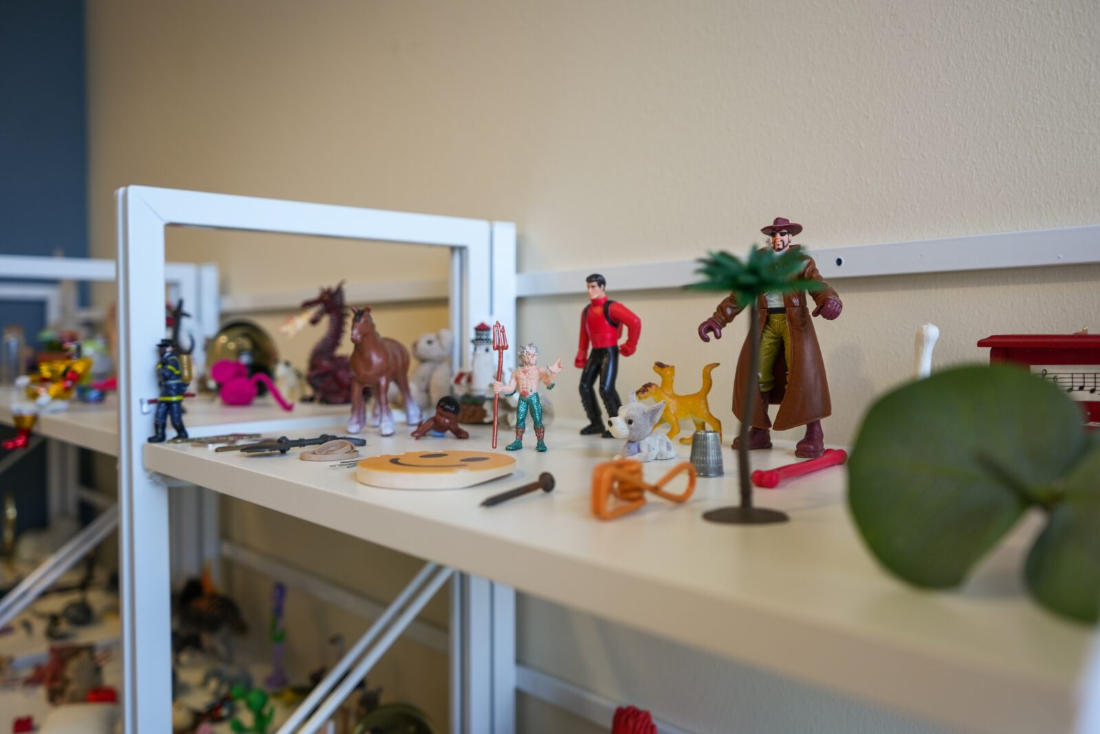 Miniature figurines and objects placed on a shelf.